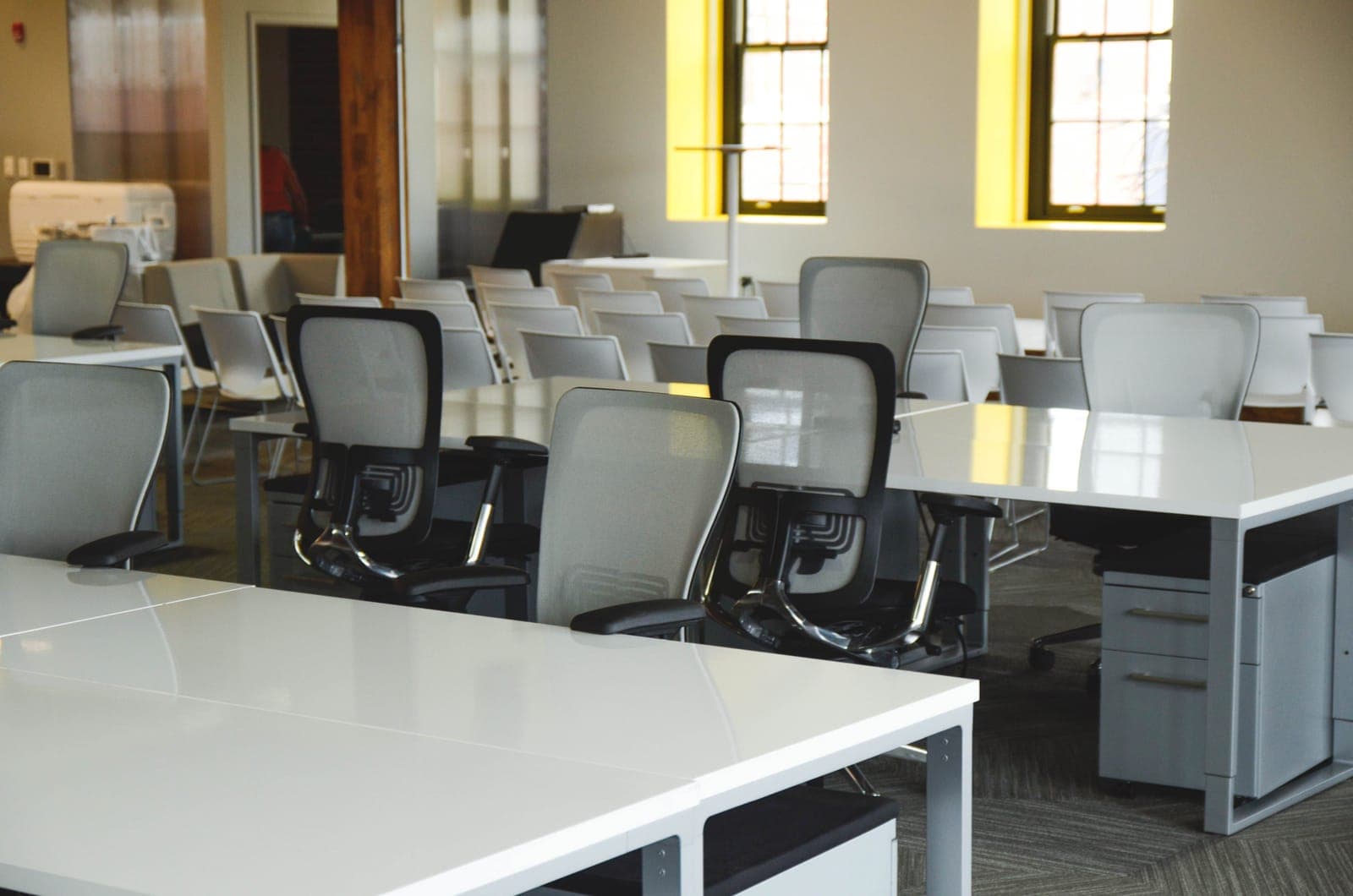 An empty office chair pushed back from a desk