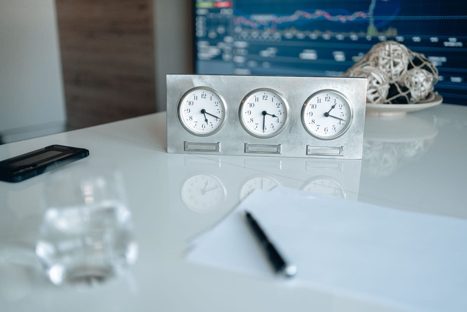 A clock on a desk beside a keyboard