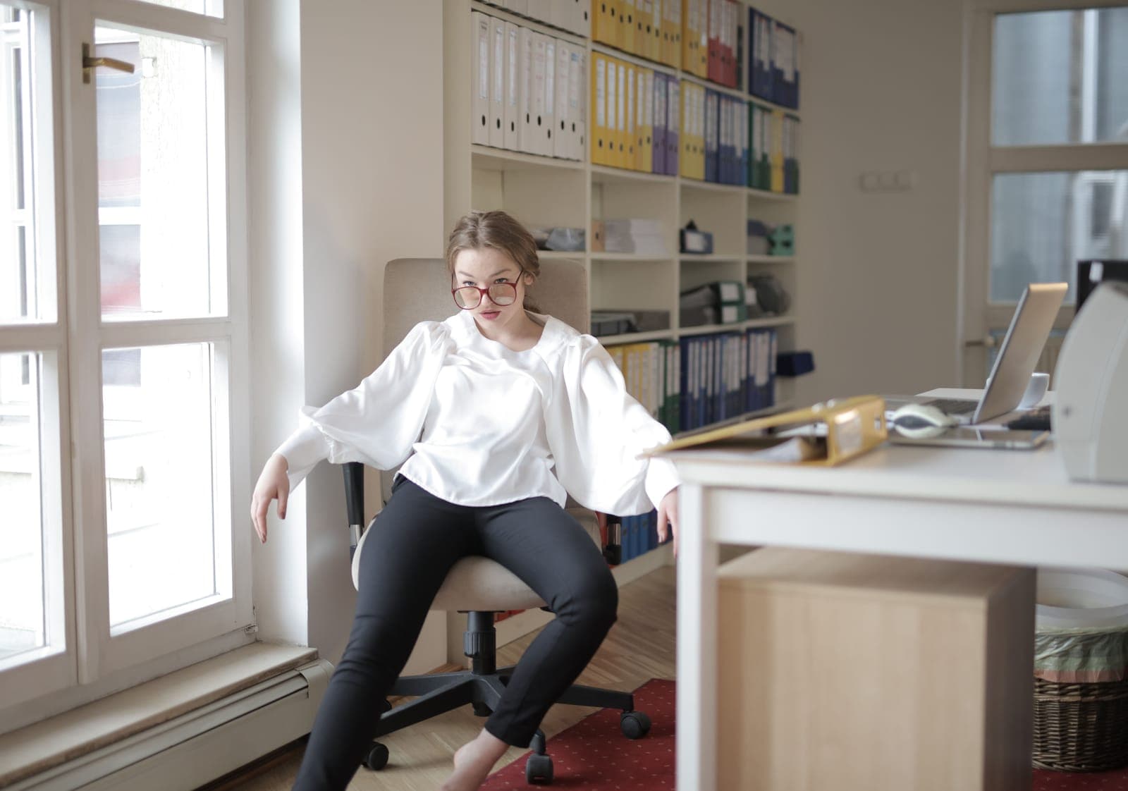 Person seated upright at a desk with feet flat on the floor