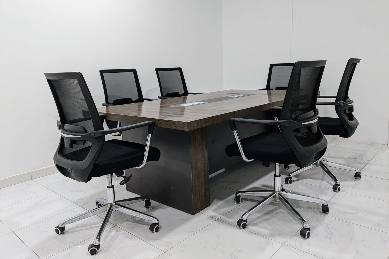 A mesh office chair backlit by a window