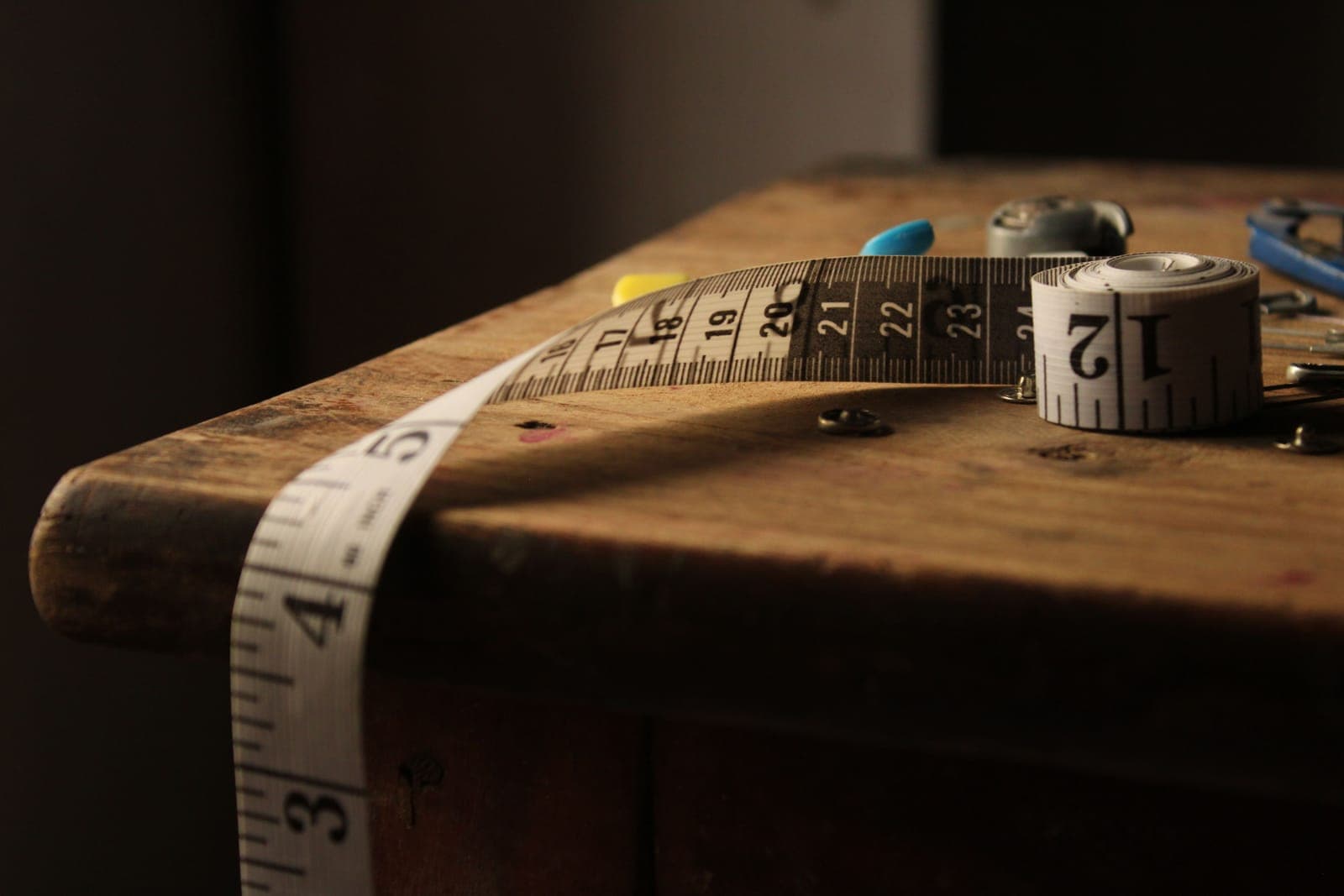 A tape measure and notebook beside an office chair seat